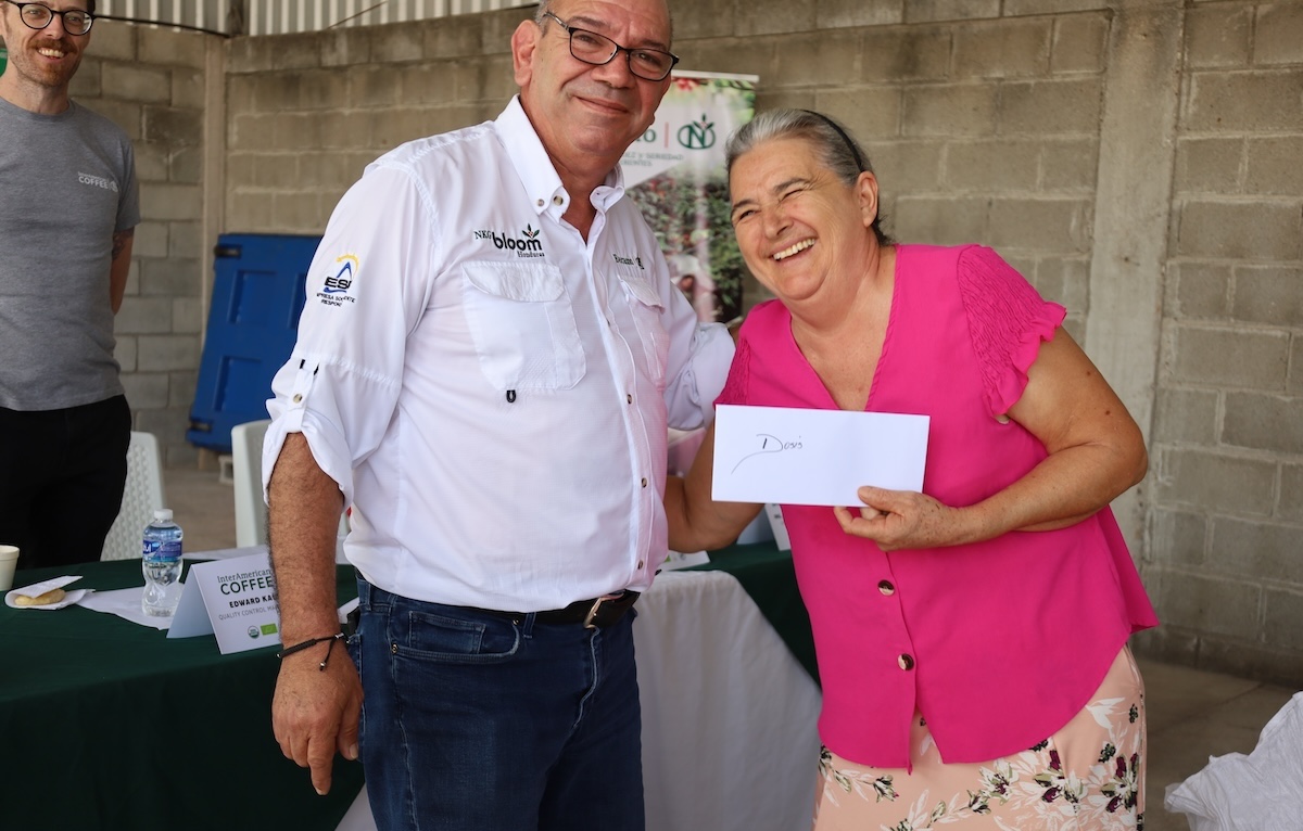 A woman coffee producer receives a "premium" — additional payment for producing certified Organic coffee.